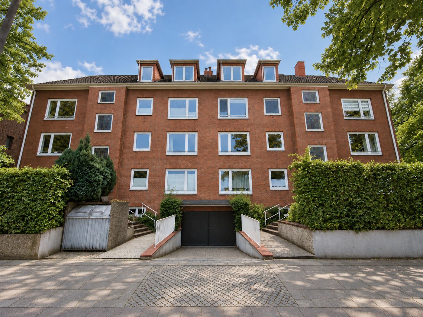 Straßenansicht des viergeschossigen Klinker-Mehrfamilienhauses mit Gauben